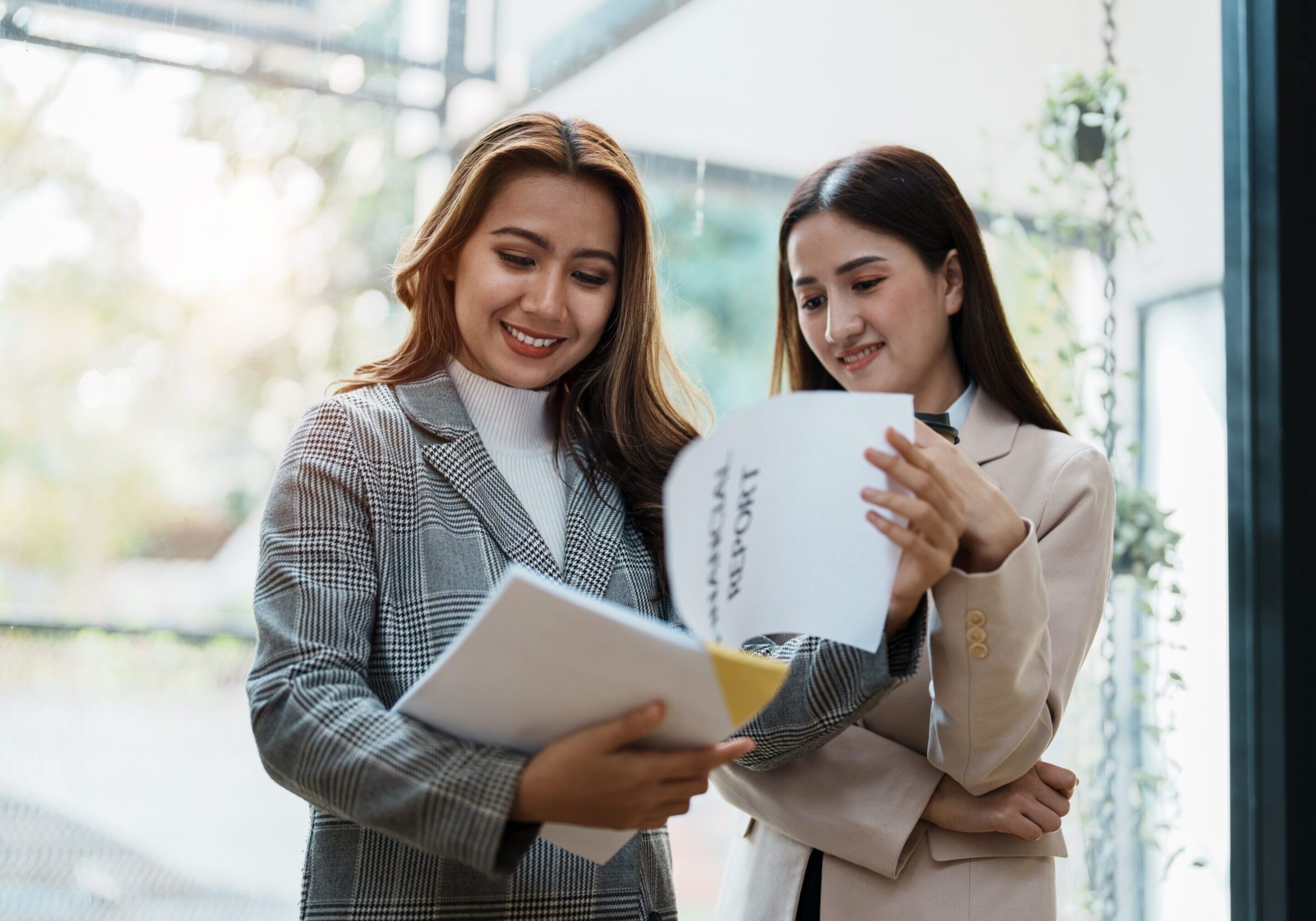 Two professional women examining a document, collaborating on important information