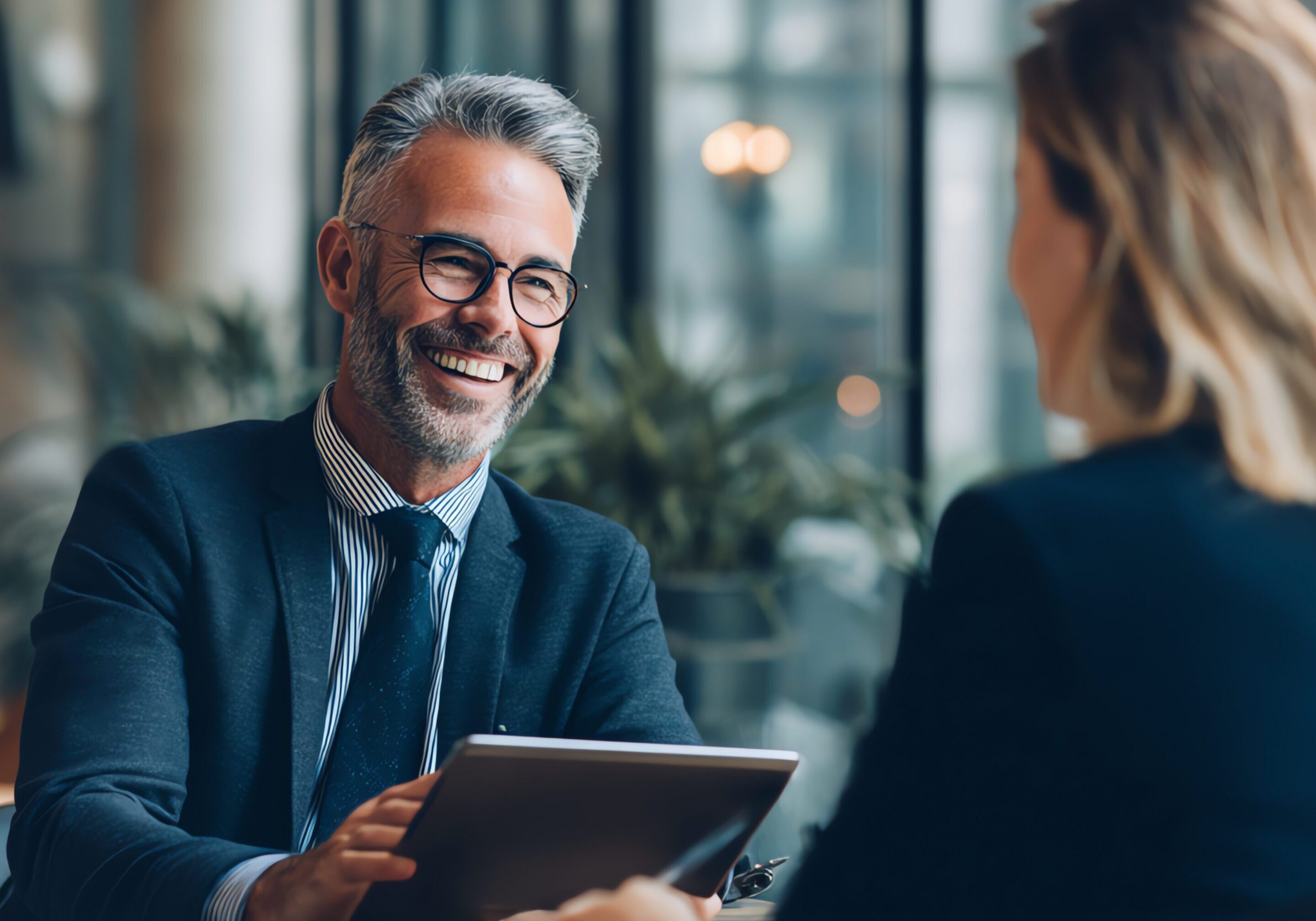 A man in a suit and tie engages in conversation with a woman
